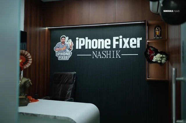 Reception desk at iPhone Fixer Nashik, with the illuminated iPhone Fixer Nashik sign behind it